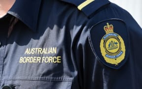 An Australian Border Force (ABF) badge can be seen on an officer's shirt.