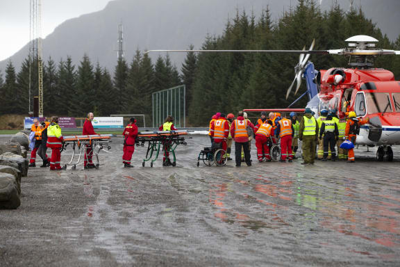 Rescuers wait to assist stranded passengers who were airlifted by helicopter from the cruise ship Viking Sky on March 24, 2019 in Hustadvika on the west coast of Norway near Romsdal.