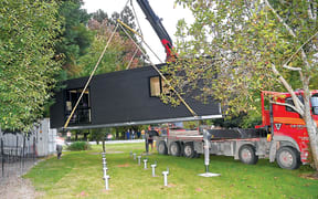 A self-contained home is dropped onto a section at Te Karaka in Tairāwhiti on 6 April. Fifteen of the relocatable pods are being delivered to the region this month for people affected by Cyclone Gabrielle.