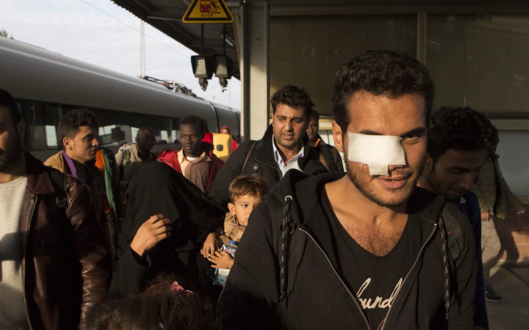 Refugees walk on a Berlin railway platform platform after getting out of a special train coming from Munich.