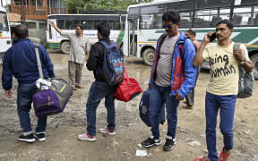 Tourists wait for buses to leave Kashmir in Srinagar on August 3, 2019.