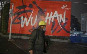 A man wearing a protective facemask walks along a street in Wuhan on 26 Januar, a city at the epicentre of a novel coronavirus outbreak.