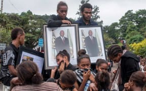 People in Port Vila mourn during the funeral procession of the late president Baldwin Lonsdale
