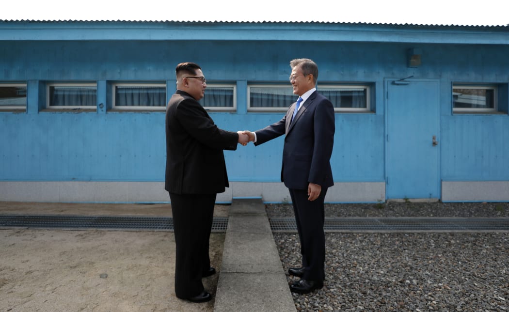 North Korea's leader Kim Jong Un (L) shakes hands with South Korea's President Moon Jae-in (R) at the Military Demarcation Line that divides their countries ahead of their summit at the truce village of Panmunjom on April 27, 2018.