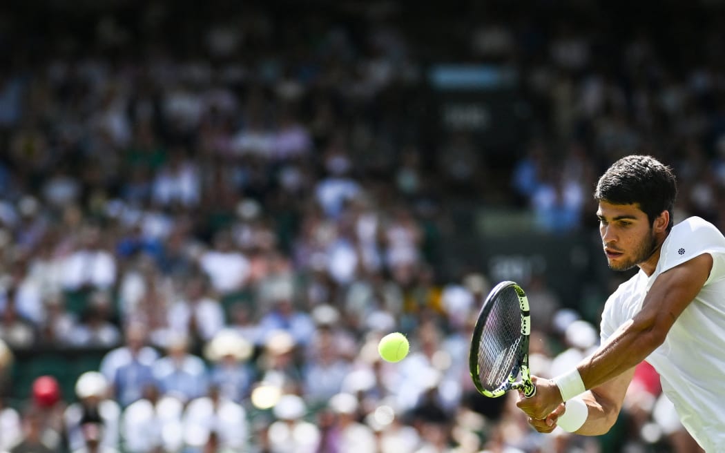 Spania Carlos Alcaraz îi returnează mingea francezului Alexandre Muller în timpul meciului de tenis de simplu masculin din ziua a cincea a Campionatului de la Wimbledon 2023 de la All England Tennis Club din Wimbledon, sud-vestul Londrei, pe 7 iulie 2023 (Foto de Sebastien Bozon/AFP) / legat de editare