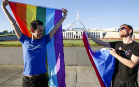 Equality ambassadors and volunteers from the Equality Campaign celebrate as they gather in front of Parliament House in Canberra.