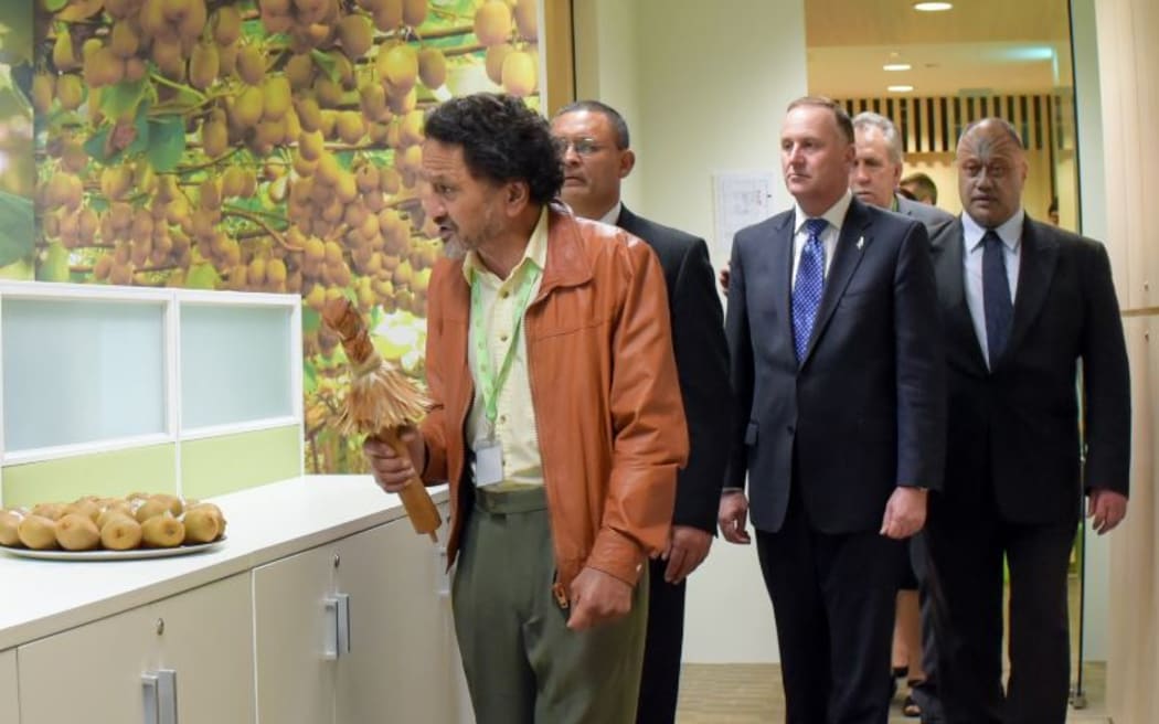 Prime Minister John Key takes part in the Maori blessing of the Singapore office, led by carver James Tapiata (left).