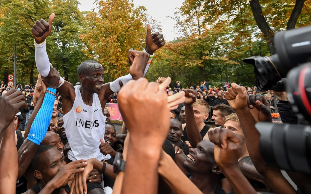 Eliud Kipchoge celebrates breaking the two hour barrier for a marathon distance with supporters and his team in Vienna.