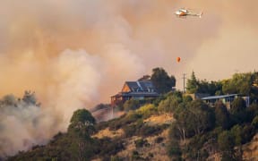 Firefighters try to save a house on the Port Hills.