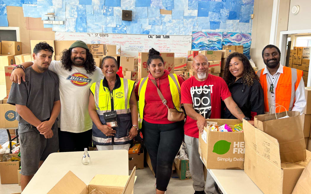 Wesley Primary School principal Lou Reddy, at right, with the team from the Ark Project standing behind a table of food for kai parcels.