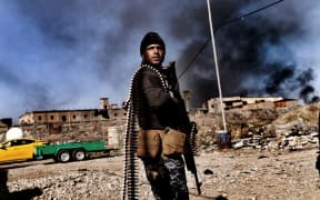 A member of Iraq's elite Rapid Response Division holds position in the northern city of Mosul as they continue the offensive to retake the city's western half from Islamic State (IS).