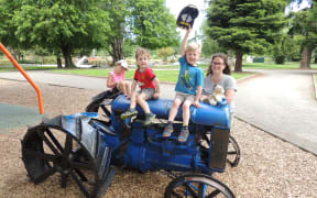 Masterton mother Abby Hollingsworth with her children Lucy, 7, Zane, 5, and Troy, 3 at the town's playground. The local district council is proposing removing the tractor and a bulldozer as they do not meet safety standards.