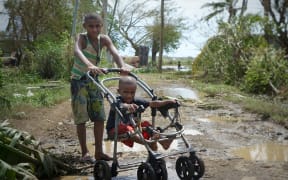 Children on muddy roads at Lovu.
