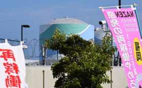 A nuclear reactor building can be seen through banners protesting the restarting of the Kyushu Electric Power plant in Sendai.