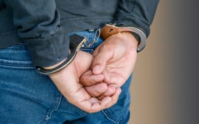Male hands locked in handcuffs on white, With Clipping Path.