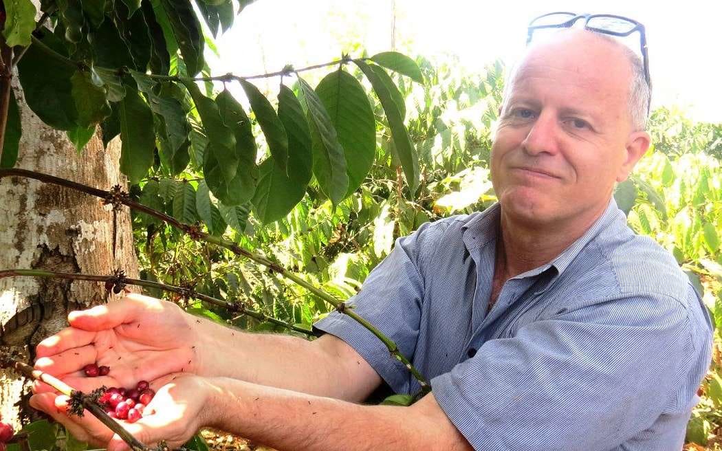 Jonathan Schwass holding coffee beans in Timor Leste.