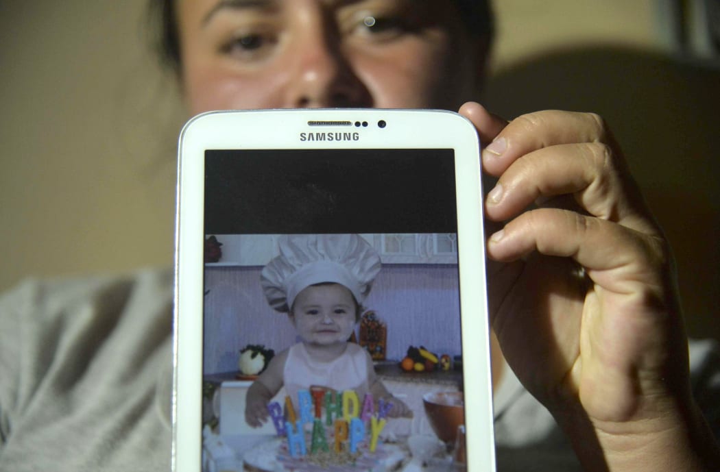 Colombian Natalia Rincon shows a picture of baby Jhoset Diaz.