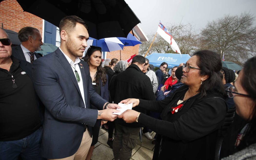 Far North councillor Moko Tepania (left) receives the Stop SNAs petition delivered by the hikoi, from Hinerangi Himiona.
