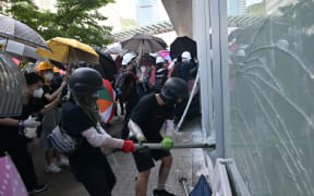 Protesters attempt to break a window at the government headquarters in Hong Kong.