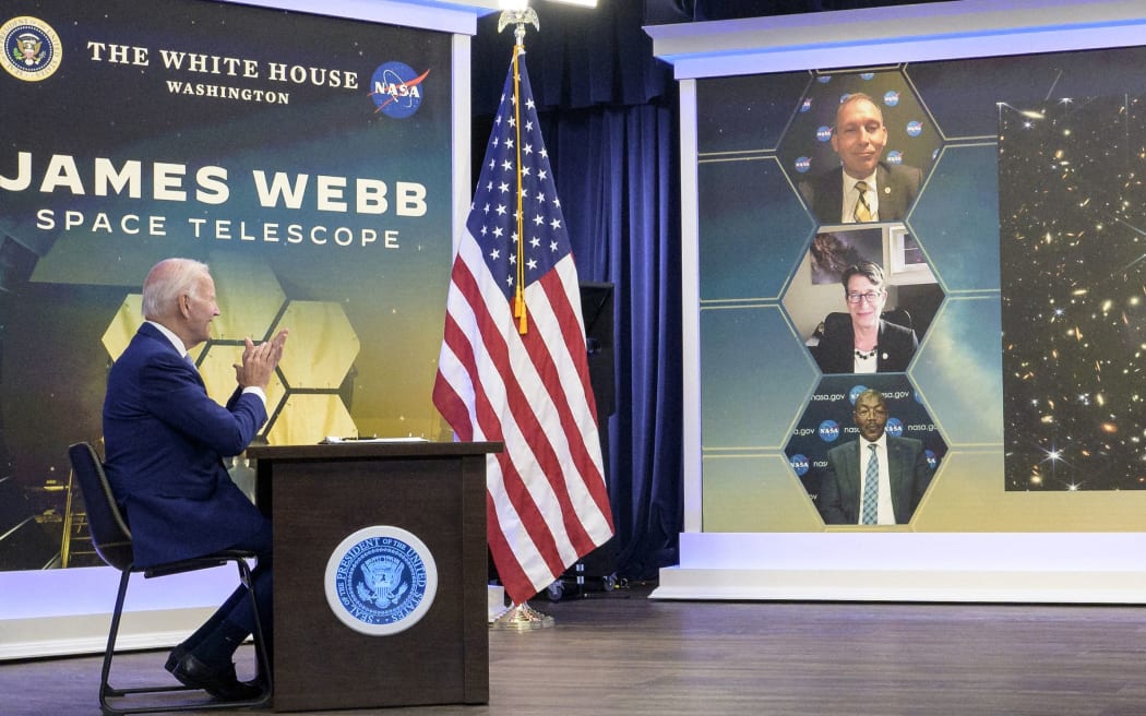 En esta imagen de volante de la NASA, el presidente de EE. UU., Joe Biden, ve la primera imagen en color del Telescopio Espacial James Webb de la NASA, la imagen de mayor resolución del universo infrarrojo en la historia, el 11 de julio de 2022, en el South Court Auditorium en la Oficina Ejecutiva de Eisenhower. edificio en el complejo de la Casa Blanca en Washington.  - La visión de la humanidad del cosmos distante nunca volverá a ser la misma.  El telescopio espacial James Webb, el más poderoso que se ha puesto en órbita, ha revelado la imagen más clara hasta la fecha del universo primitivo, que data de hace 13.000 millones de años, dijo la NASA el lunes.  La impresionante foto, publicada en una sesión informativa en la Casa Blanca por el presidente Joe Biden, está llena de miles de galaxias y presenta algunos de los objetos más débiles observados, coloreados en tonos de azul, naranja y blanco.  (Foto de Bill INGALLS / NASA / AFP) / RESTRINGIDO A USO EDITORIAL - CRÉDITO OBLIGATORIO "FOTO AFP/NASA/...