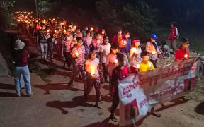 This handout photo taken and released by Dawei Watch on March 27, 2021 shows protesters holding candles as they take part in a demonstration against the military coup in a village near Dawei. (