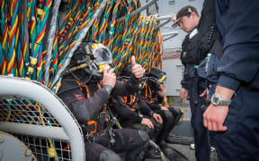 A navy diver gives the 'thumbs up' prior to diving from HMNZS Manawanui during a training session in Akaroa Harbour on 26 October 2015.