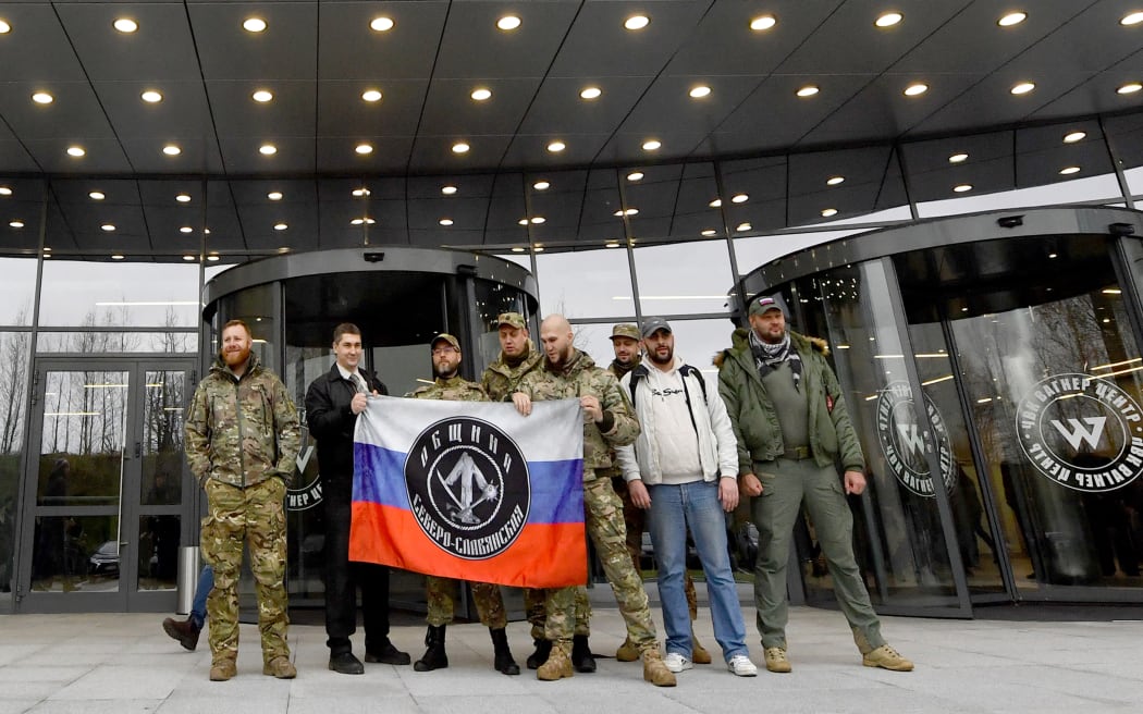 Members of the Wagner Group stand outside their new headquarters in St. Petersburg in military camouflage on November 4, 2022.