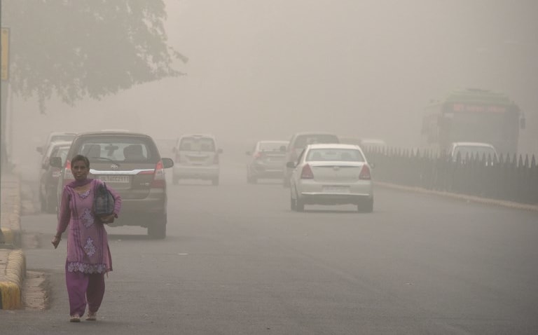An Indian woman walks on a road during heavy smog conditions in New Delhi.