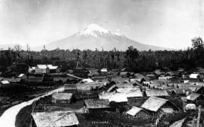 Parihaka Pa, circa 1900, with Mount Taranaki - taken by an unidentified photographer.
