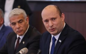 Israeli Prime Minister Naftali Bennett, right, with Foreign Minister Yair Lapid, as he chairs chairs the first weekly cabinet meeting of the new government in Jerusalem, on 20 June 2021.