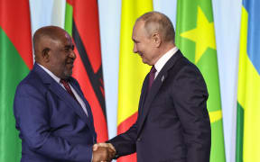 Russian President Vladimir Putin and Comoros President and the Chairperson of the African Union Azali Assoumani shake hands after delivering a joint media statement at the second Russia-Africa summit in Saint Petersburg on July 28, 2023.