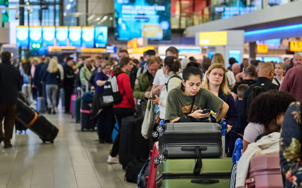 Na lotnisku Schiphol w Holandii ludzie stoją w kolejce, ponieważ sezon świąteczny wywiera presję na linie lotnicze.