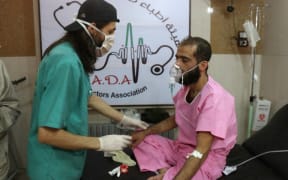 A doctor treats a Syrian man suffering from breathing difficulties at a make-shift hospital in Aleppo after regime helicopters dropped barrel bombs on the rebel-held Sukkari neighbourhood of the northern Syrian city on September 6, 2016.