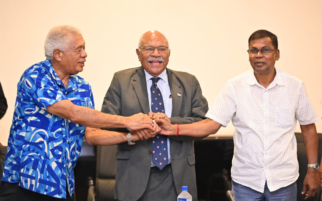 People's Alliance Party leader Sitiveni Rabuka (centre) joins hands with the coalition partners, Biman Prasad (right), leader of the National Federation Party, and Anare Jalu, chair of the Social Democratic Liberal Party (SODELPA), after an agreement to form a new government in Suva on 20 December, 2022.