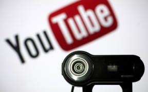 A webcam is positioned in front of YouTube's logo. Google agreed to pay a $170 million fine to settle charges that it illegally collected and shared data from children on its YouTube video service without consent of parents, US officials announced on September 4, 2019.