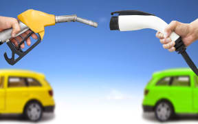 20231108 - electric car and gasoline car concept. hand holding gas pump and power connector for refuel