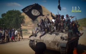 A screengrab taken on November 9, 2014 from a Boko Haram video released by the Nigerian Islamist extremist group Boko Haram and obtained by AFP shows Boko Haram fighters on a tank parading in an unidentified town.