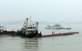 Rescue boats can be seen alongside the capsized passenger ship in the Yangtze.