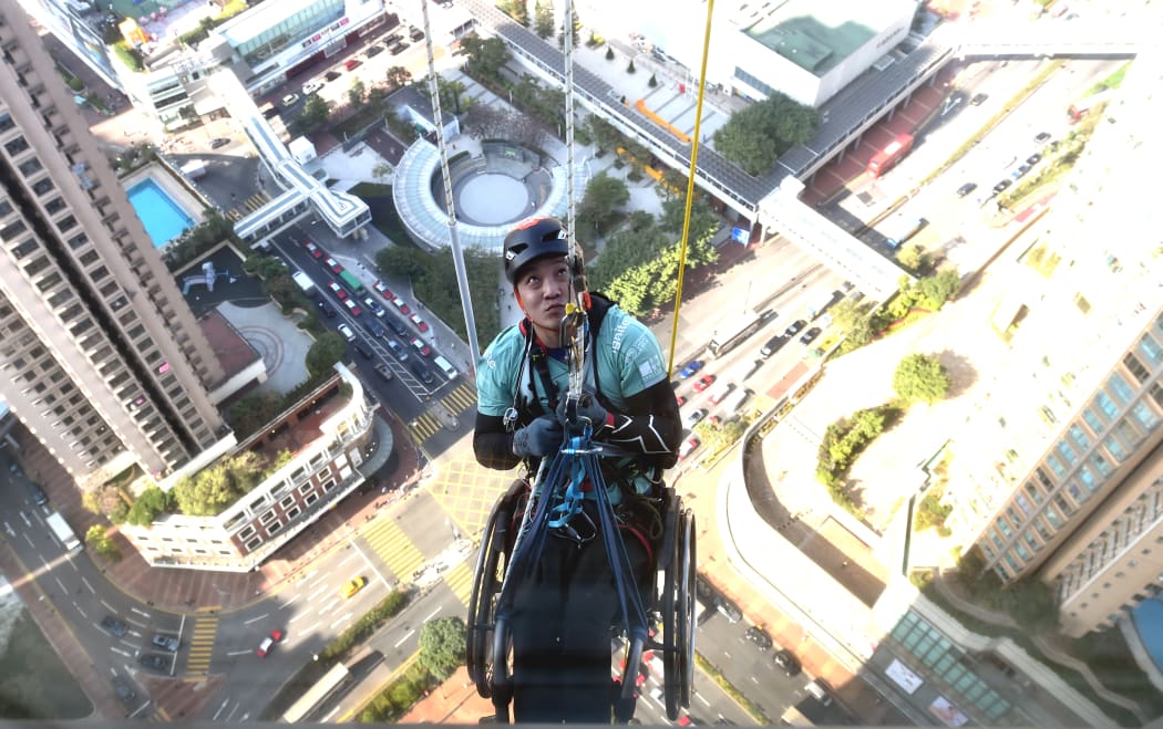 Hong Kong climber and motivational speaker Lai Chi-wai, who was paralysed in a car accident in 2011, climbs the 320m Nina Tower in Hong Kong to raise money for spinal cord patients.