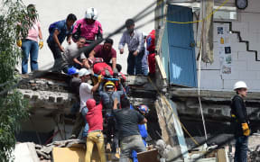 Rescuers pulling a woman alive from the rubble of a Mexico City building.
