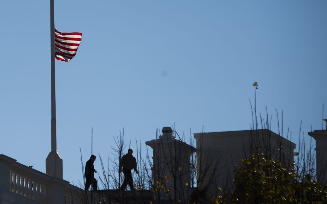 The US flag at the White House is lowered to half mast on December 3, 2015, one day after 14 people were killed in San Bernardino, California.