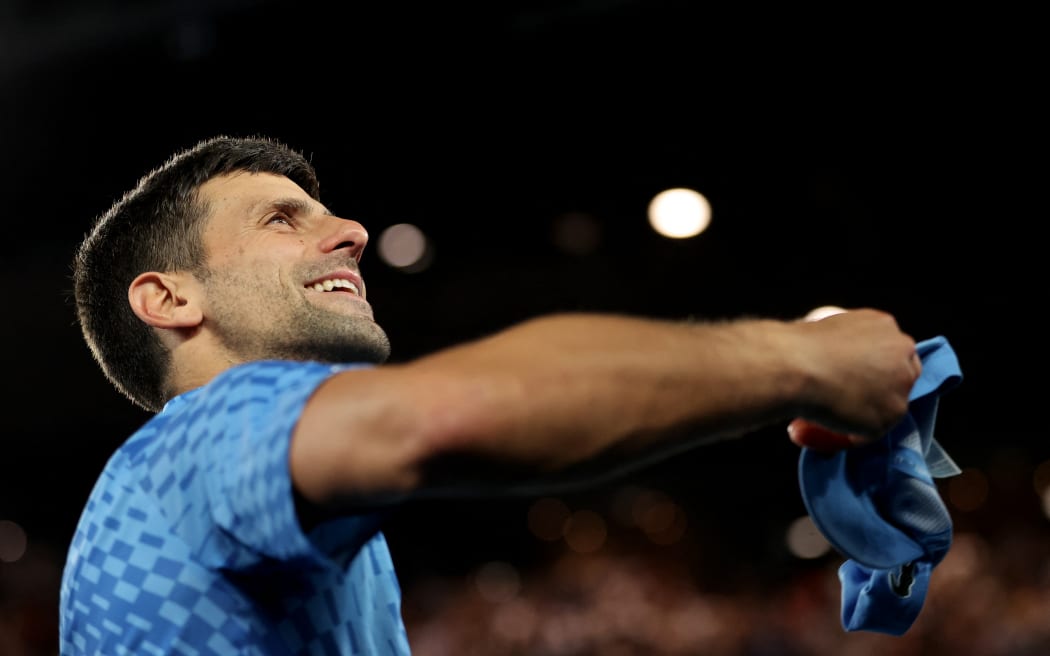 El serbio Novak Djokovic arroja un sombrero a un aficionado mientras celebra su victoria sobre el australiano Alex de Minaur después del partido individual masculino del octavo día del Abierto de Australia en Melbourne.