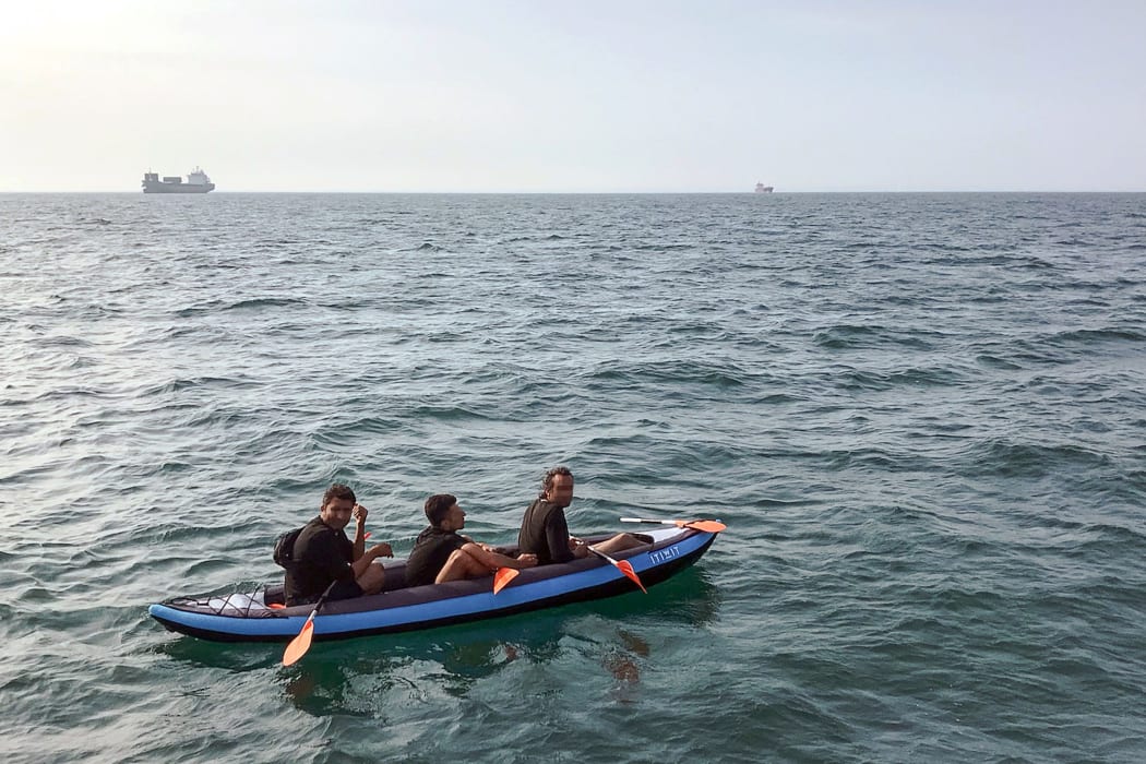 Three migrants who were attempting to cross The English Channel from France to Britain are seen as they drift in an inflatable canoe off the French coast at Calais on August 4, 2018, before being rescued.