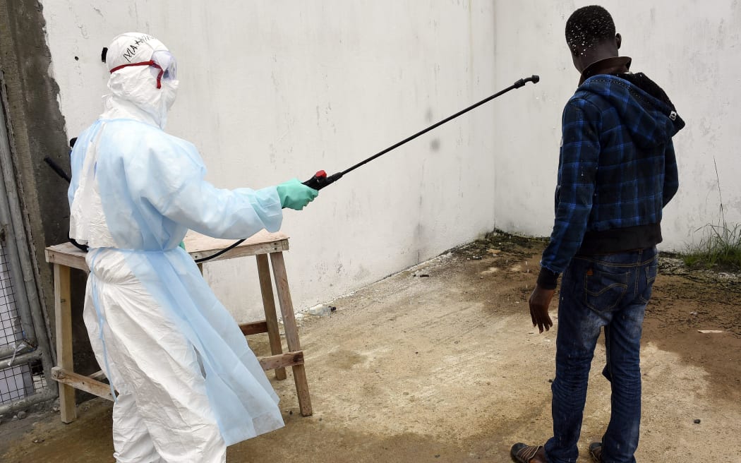 A man is decontaminated by a health worker at a hospital in the Liberian capital Monrovia.