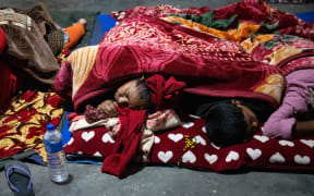 Residents sleep outdoors in Jajarkot district on November 4, 2023, after a 5.6 magnitude earthquake. At least 132 people were killed in an overnight earthquake of 5.6 magnitude that struck a remote pocket of Nepal, officials said on November 4, as security forces rushed to assist with rescue efforts. (Photo by PRABIN RANABHAT / AFP)