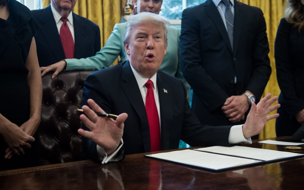 US President Donald Trump signs an executive order with small business leaders in the Oval Office at the White House in Washington DC on January 30.
