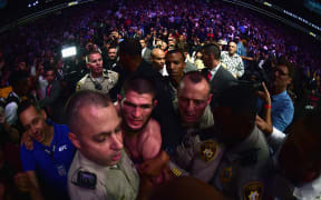 Khabib Nurmagomedov of Russia is escorted out of the arena after defeating Conor McGregor.