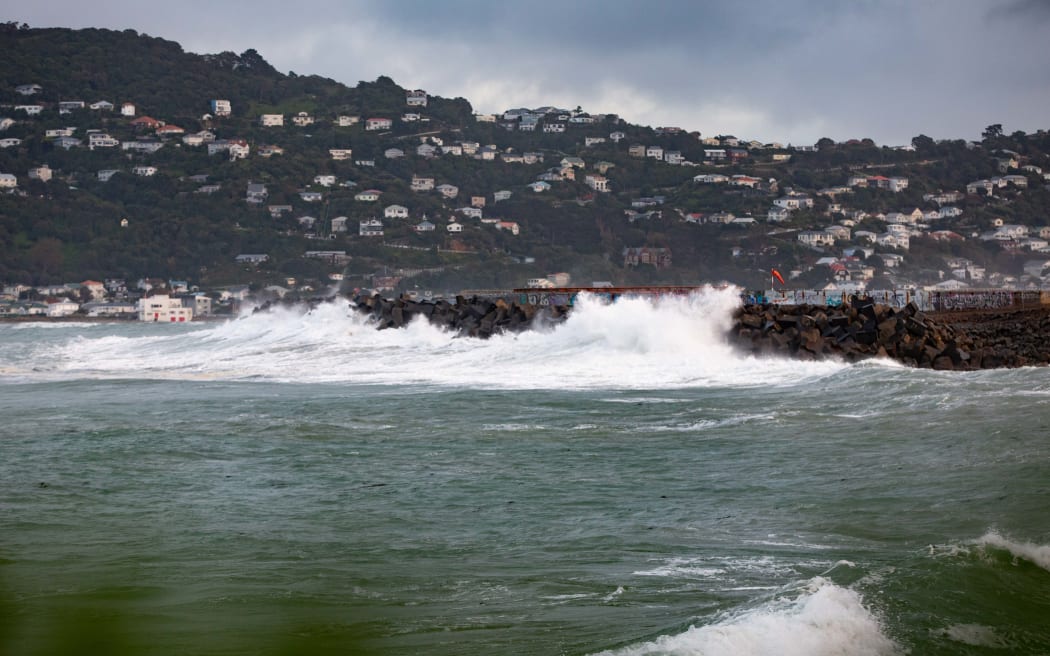 Waves crash against a sea wall near the end of Wellington Airport