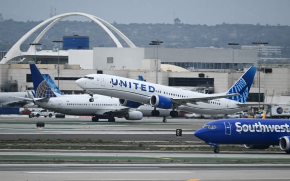 A United Airlines Boeing 737 MAX 9 airplane passes a Southwest Airlines Boeing 737 while taking off from Los Angeles International Airport (LAX) as seen from El Segundo, California, on September 11, 2023. (Photo by Patrick T. Fallon / AFP)