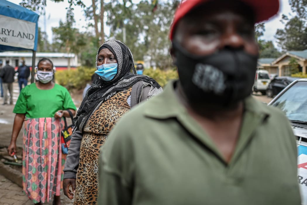 People wear face masks while queueing during a mass testing for Covid-19. File photo.